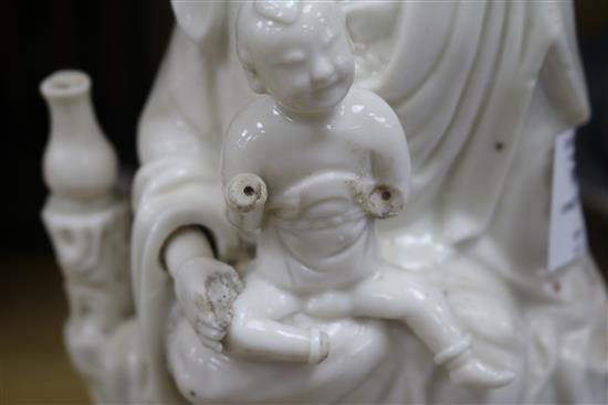 A large Chinese blanc de chine group of Guanyin and child, Kangxi period, damage and losses